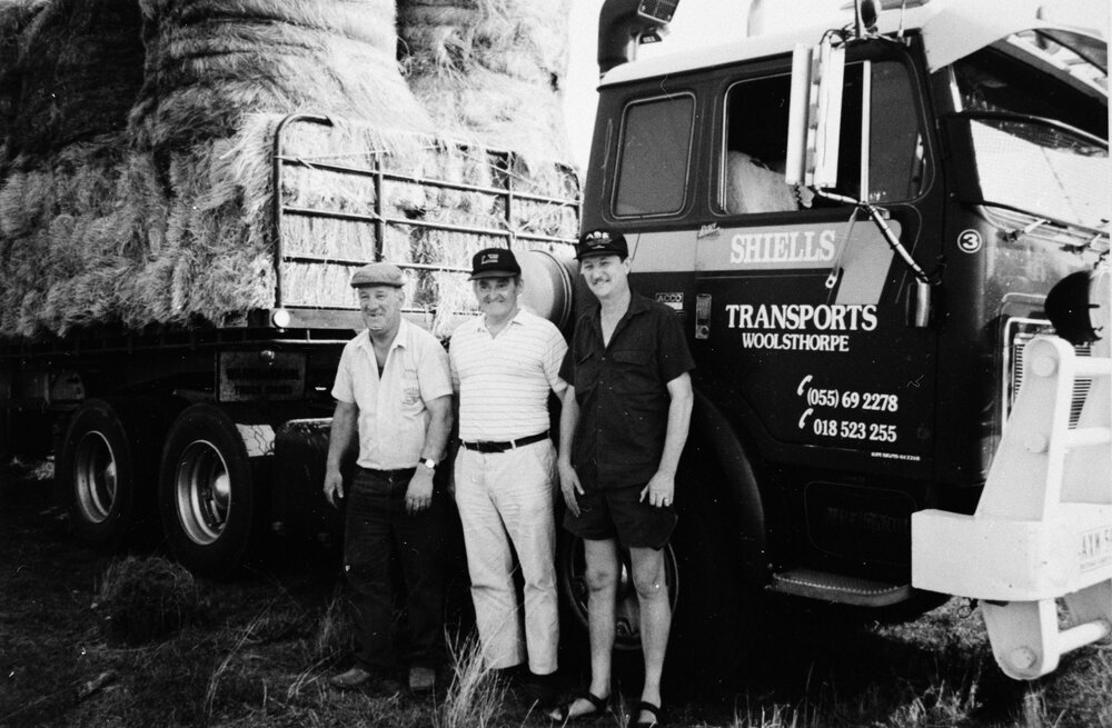 Three men beside a Shiells Transports truck, no location, no date