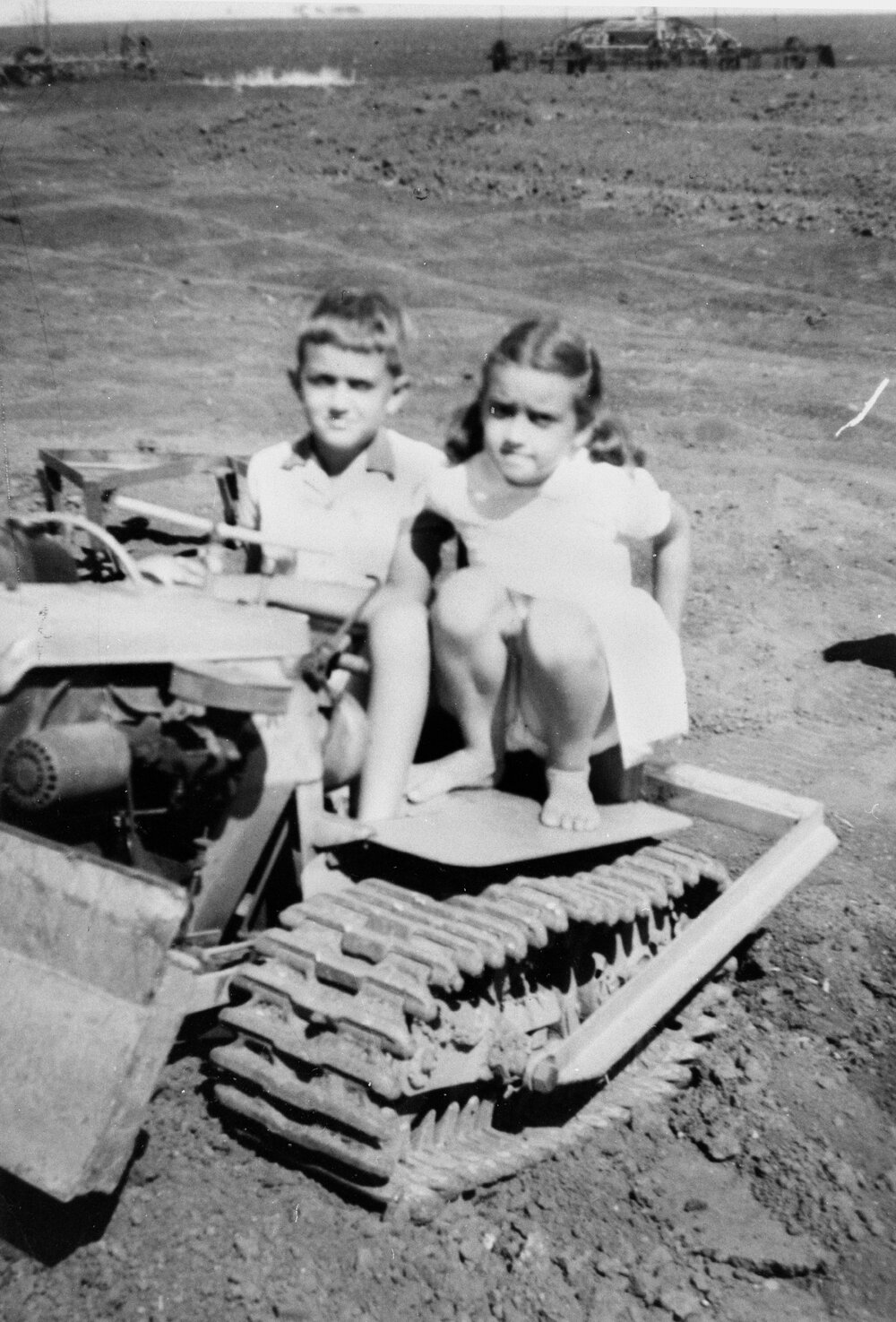 Two children on a bulldozer, no location, no date