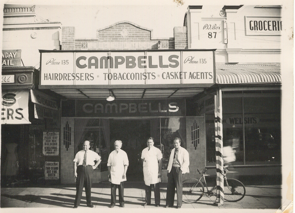Four men standing in front of Campbells, Dalby, circa 1940