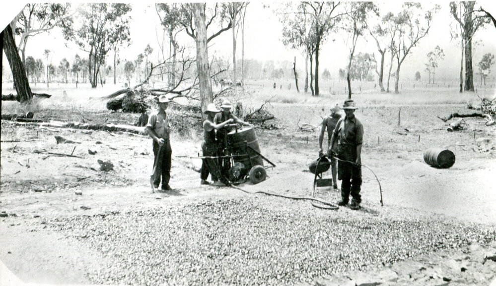 Road construction gang spraying coal tar on a floodway, Guluguba, 1940