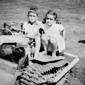 Two children on a bulldozer, no location, no date