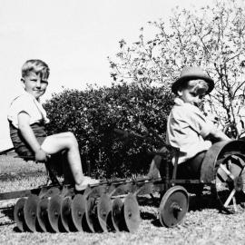 Two boys on a toy tractor, unknown location, no date